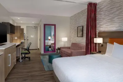 a hotel room with a bed and a living room at Home2 Suites By Hilton Bristol in Bristol