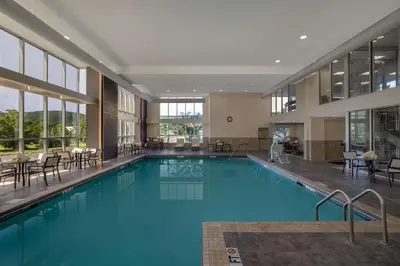 a large swimming pool in a building with tables and chairs at Home2 Suites By Hilton Bristol in Bristol