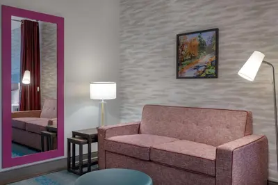 a living room with a couch and a mirror at Home2 Suites By Hilton Bristol in Bristol