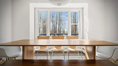 a dining room table with chairs and a large window at Hupi House - A Peaceful Wooded Lakeside Retreat in Monterey