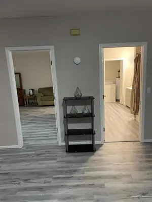 an empty living room with a table and a mirror at Private Apartment in Southbury 101 in Southbury