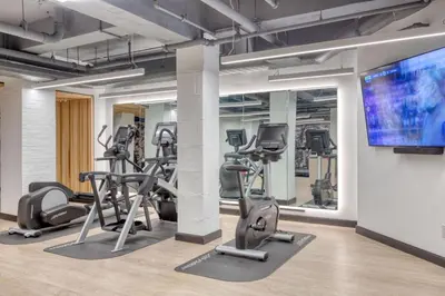 a gym with tread machines and a flat screen tv at Midtown East 2br w gym wd nr Grand Central NYC-1146 in New York