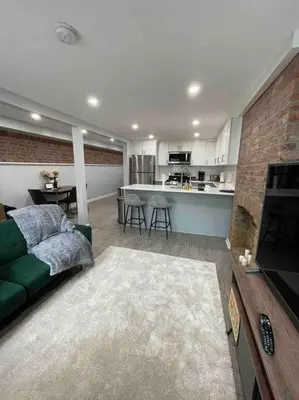 a living room with a green couch and a kitchen at Sweet Home - 20 minutes to NYC in Jersey City