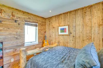 a bedroom with a wooden wall with a bed and a guitar at Windham Mountain Vacation Rental about 3 Mi to Lifts! in Windham