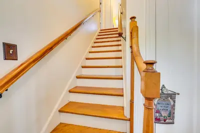 a staircase in a home with white walls and wooden floors at Pet-Friendly Gloversville Cottage Near Golf Course in Gloversville