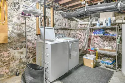 a washing machine in a room with a stone wall at Pet-Friendly Gloversville Cottage Near Golf Course in Gloversville
