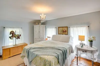 a bedroom with a large bed and a chandelier at Family Ski Getaway 6 Mi to Berkshire East! in Hawley
