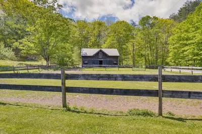 a barn in the middle of a field with a fence at Family Ski Getaway 6 Mi to Berkshire East! in Hawley