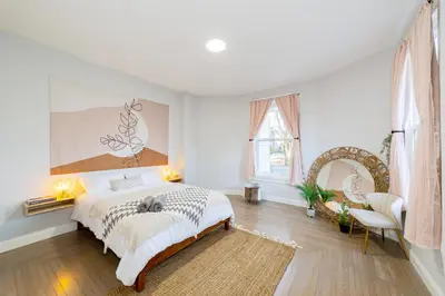 a white bedroom with a bed and a large window at The East Rock, 4BR, On-site Parking, Washer & Dryer, Walk to Yale in New Haven