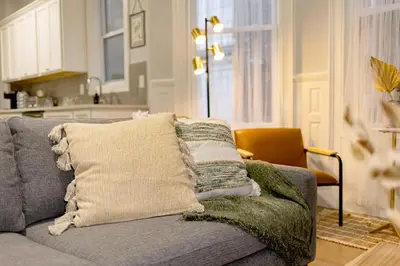 a couch with pillows on it in a living room at The East Rock, 4BR, On-site Parking, Washer & Dryer, Walk to Yale in New Haven