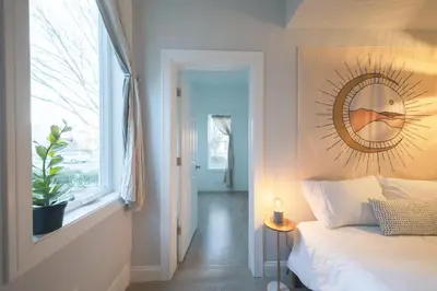 a bedroom with a bed and a mirror on the wall at The East Rock, 4BR, On-site Parking, Washer & Dryer, Walk to Yale in New Haven