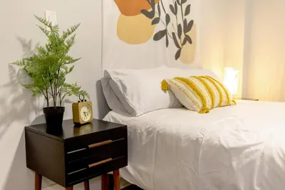 a bedroom with a bed and a nightstand with a clock at The East Rock, 4BR, On-site Parking, Washer & Dryer, Walk to Yale in New Haven