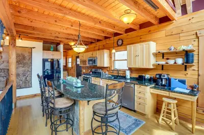 a kitchen with a table and chairs in a cabin at Massachusetts Vacation Rental with Deck and Grill in Cheshire