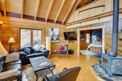 a living room with a fireplace in a log cabin at Massachusetts Vacation Rental with Deck and Grill in Cheshire