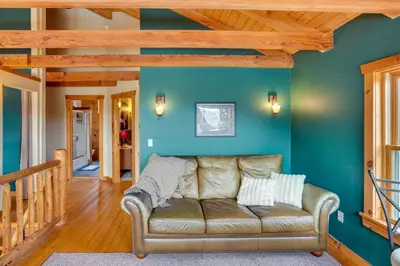 a living room with blue walls and a couch at Massachusetts Vacation Rental with Deck and Grill in Cheshire