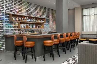 a bar with a row of orange bar stools at Residence Inn by Marriott New York Queens in Queens