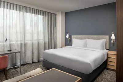 a bedroom with a large white bed and a desk at Residence Inn by Marriott New York Queens in Queens