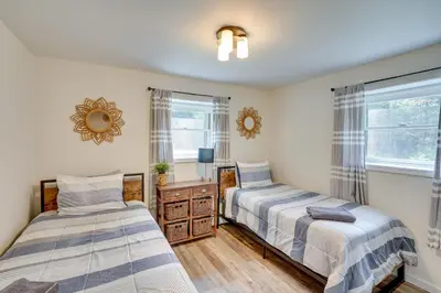 two beds in a room with two windows at 6 Mi to Hunter Mtn Winter Retreat with Hot Tub! in Tannersville