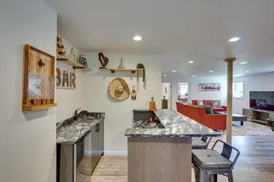 a kitchen with granite counter tops and a living room at 6 Mi to Hunter Mtn Winter Retreat with Hot Tub! in Tannersville