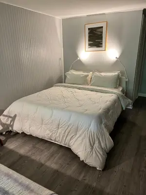 a bedroom with a large bed with a white comforter at Mid-Century DJs Dream near Rhinebeck in Staatsburg