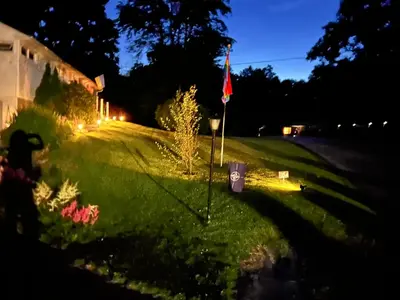 a yard with a flag in the grass at night at Mid-Century DJs Dream near Rhinebeck in Staatsburg