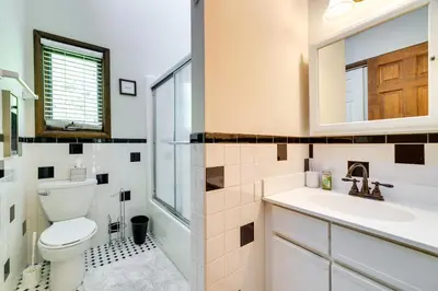 a bathroom with a toilet and a sink and a mirror at Exciting Tobyhanna Home Near Kalahari Water Park! in Tobyhanna