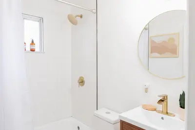 a white bathroom with a shower and a sink at Retro Retreat renovated 2BR, desk, no chore list! in Kingston