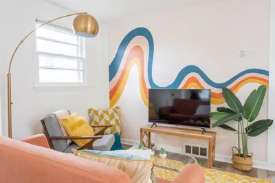 a living room with a rainbow mural on the wall at Retro Retreat renovated 2BR, desk, no chore list! in Kingston