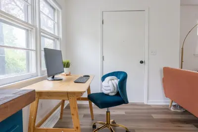 a desk with a computer and a blue chair at Retro Retreat renovated 2BR, desk, no chore list! in Kingston