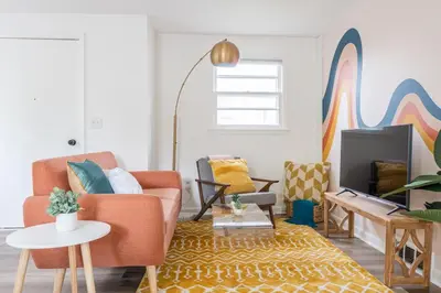 a living room with a couch and a tv at Retro Retreat renovated 2BR, desk, no chore list! in Kingston