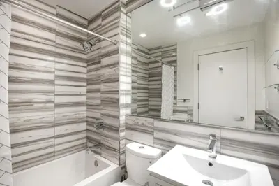 a bathroom with a sink and a tub and a toilet at UWS 1BR w Gym WD Doorman nr Central Park NYC-377 in New York