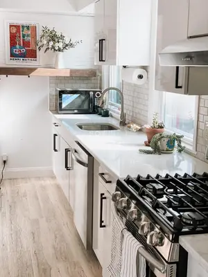 a white kitchen with a stove and a sink at Designer Home 2 Bedroom - 20min to NYC WTC - Private Backyard in Harrison