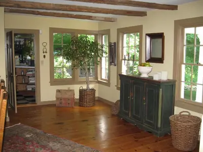 a living room with a tree and a cabinet at Private setting on country farm near Rhinebeck in Clinton Corners