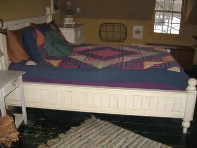 a bed with a quilt on it in a bedroom at Private setting on country farm near Rhinebeck in Clinton Corners