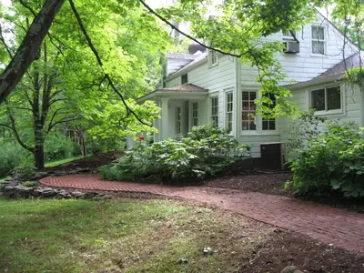 a white house with a brick walkway in front of it at Private setting on country farm near Rhinebeck in Clinton Corners