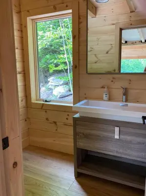 a bathroom with a sink and a window in a log cabin at WoodHunterHome in Platte Clove
