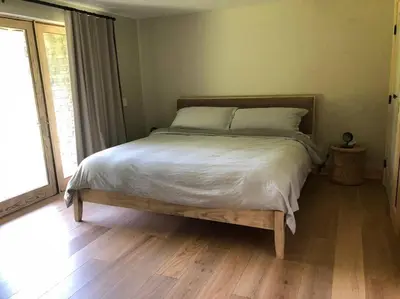 a bed in a bedroom with a wooden floor at WoodHunterHome in Platte Clove