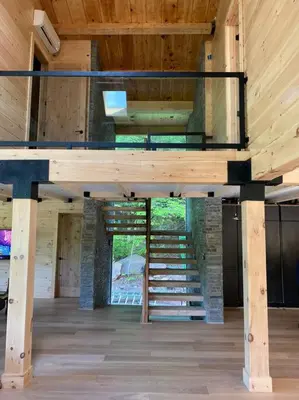 a staircase in the middle of a room with wooden ceilings at WoodHunterHome in Platte Clove