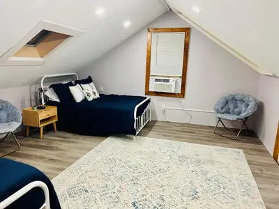 a bedroom with a bed and two chairs at The country house in Greenwood Lake