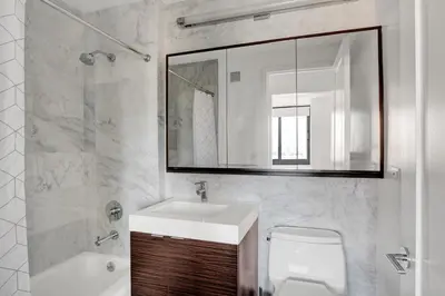 a bathroom with a sink and a toilet and a mirror at Tribeca Studio w Pool Roofdeck Gym View NYC-273 in New York