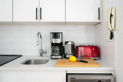 a kitchen with a counter top with a sink and a counter at 444-3E Contemporary 1BR in Hell's Kitchen in New York