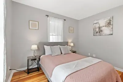 a bedroom with a bed and two lamps and a window at Stylish, Relaxing & Comfy 3 BDR Home in Bristol