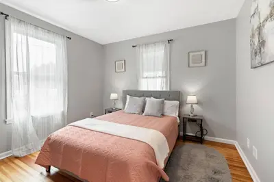 a bedroom with a large bed and two windows at Stylish, Relaxing & Comfy 3 BDR Home in Bristol