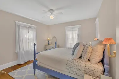 a bedroom with a blue bed and two windows at Charming New England Home in West Hartford Center in West Hartford