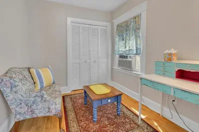 a living room with a chair and a table at Charming New England Home in West Hartford Center in West Hartford