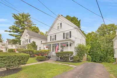 a white house with an american flag at Charming New England Home in West Hartford Center in West Hartford