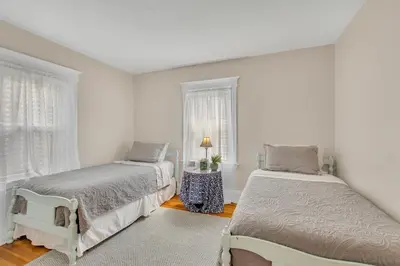 a white room with two beds and a window at Charming New England Home in West Hartford Center in West Hartford