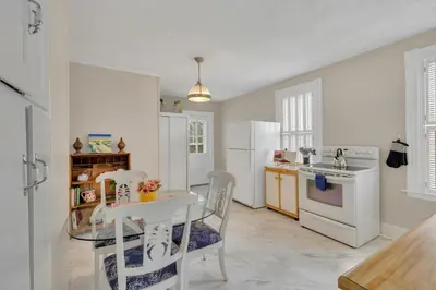 a white kitchen with a table and chairs in it at Charming New England Home in West Hartford Center in West Hartford