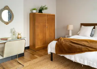 a bedroom with a bed and a dresser with a mirror at Elegant Townhouse, Hudson center, 3 ensuite baths in Hudson