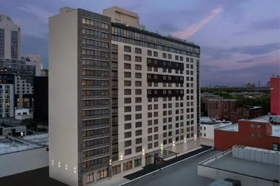 a tall white building on top of a city at SpringHill Suites by Marriott New York Queens in Queens